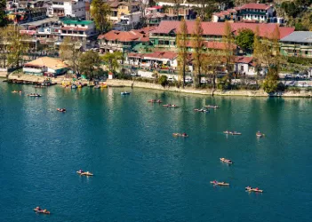 Scenic Lake surrounded by green hills and colorful hillside buildings in Nainital