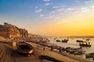 Stunning view of Varanasi's ghats during golden hour with boats on the Ganges River